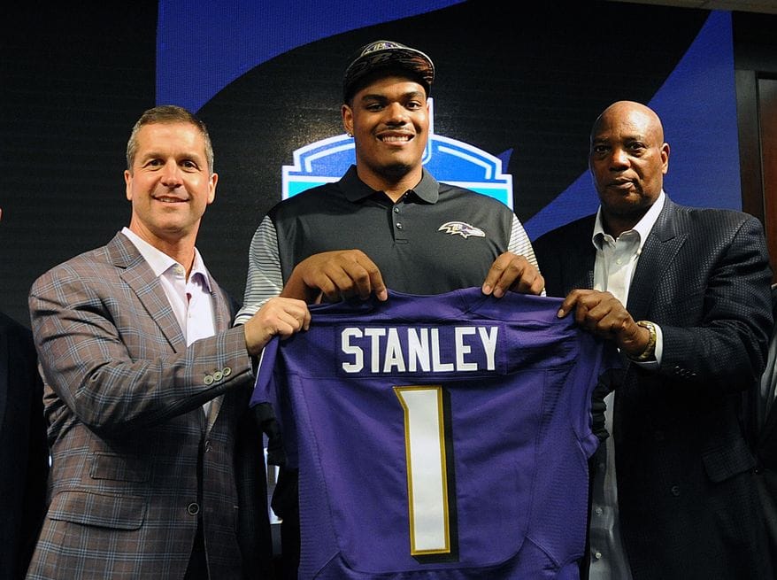 Baltimore Ravens first round draft pick Ronnie Stanley, center, holds up his jersey with head coach John Harbaugh, left, and general manager Ozzie Newsome, before a news conference Friday, April 29, 2016, in Owings Mills, Md. (AP Photo/Gail Burton) 